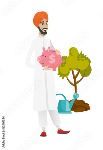 Hindu farmer holding a piggy bank.