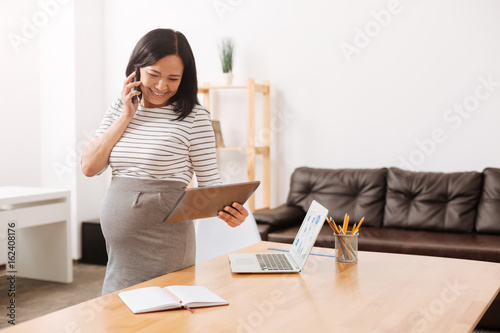 Fotografía Joyful pregnant woman working in the office