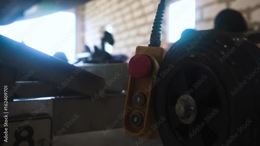 Winch red buttom remote controller in workroom workshop near truck and boat. 4k UHD.