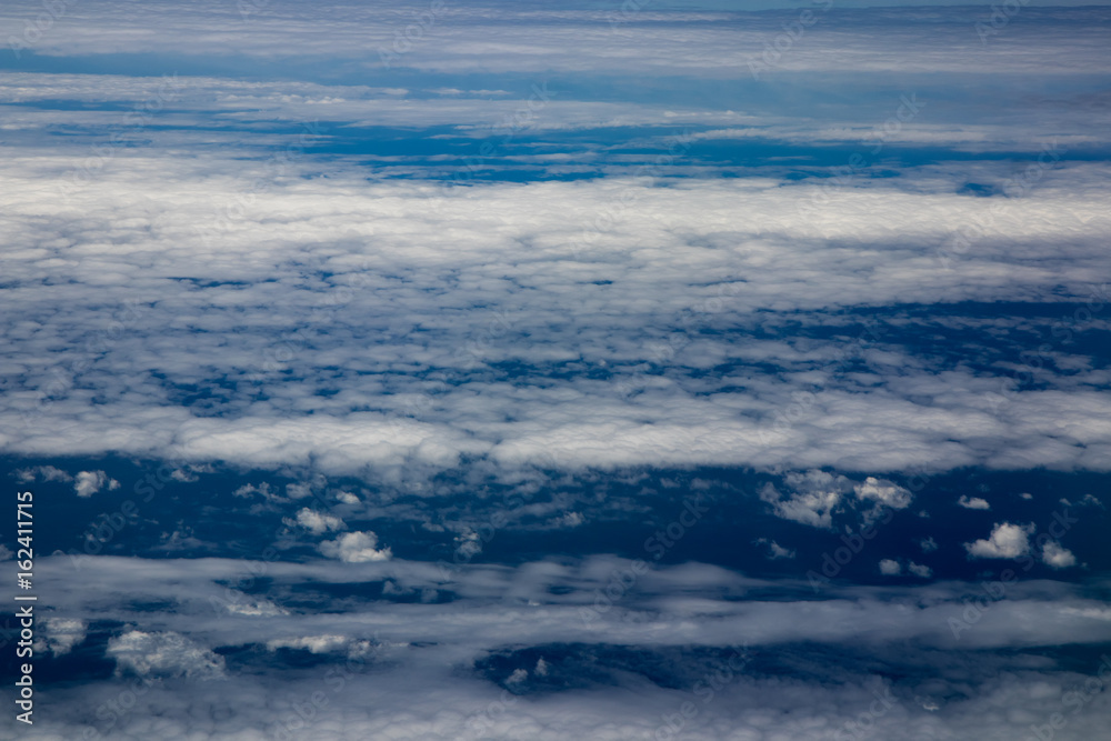 Aerial view of clouds and blue sky while flying on aircraft