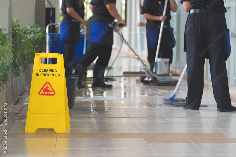 Obraz premium Cropped image of woman in protective gloves using a flat wet-mop and machine while cleaning floor