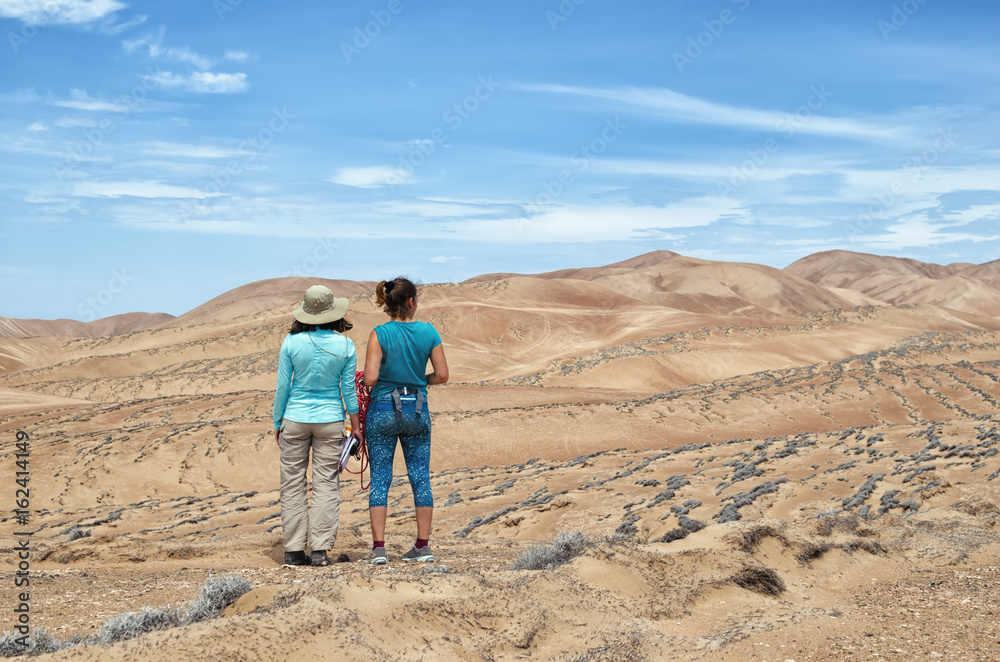 two young women exploring the desert - back view