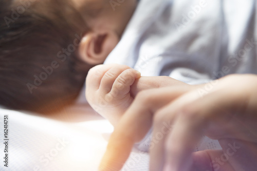 The mother is holding the hand of the baby . Mother's and baby's hands. Family concept 