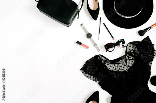 Trendy fashion black styled woman clothes and accessories collection on white background. Flat lay, top view. Dress, high heels, sunglasses, purse, watches.