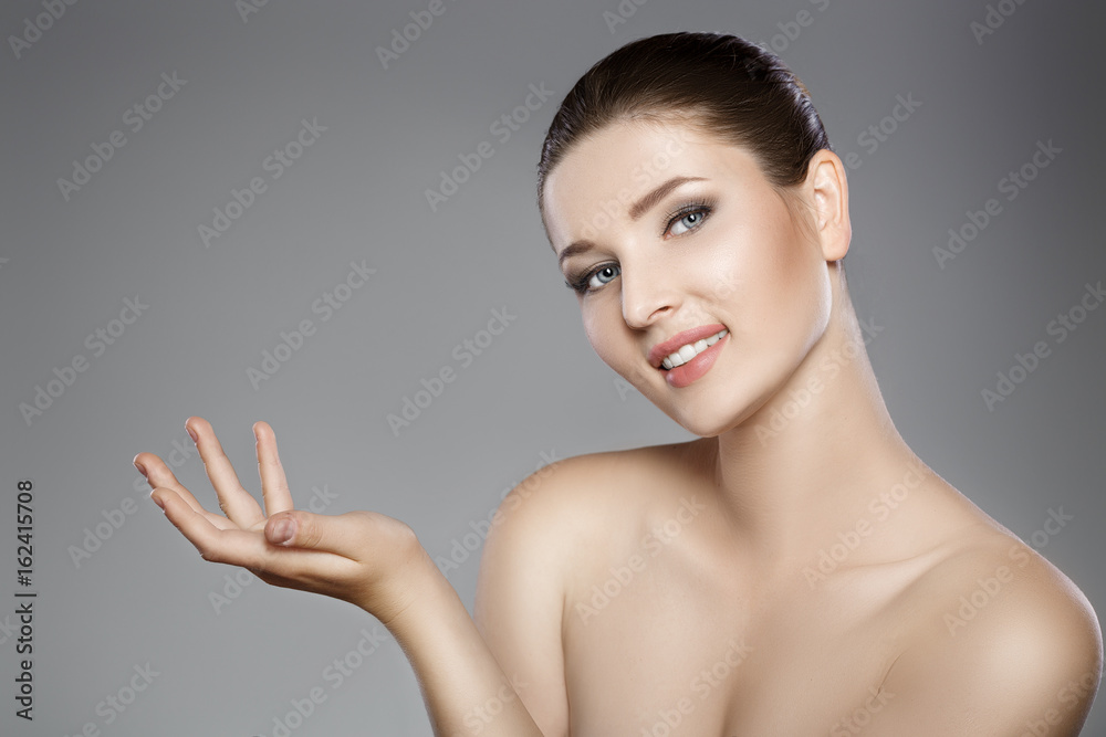 beautiful woman's face with blue eyes and clean fresh skin. girl is pointing at something beautiful woman's face with blue eyes and clean fresh skin. girl is pointing at something