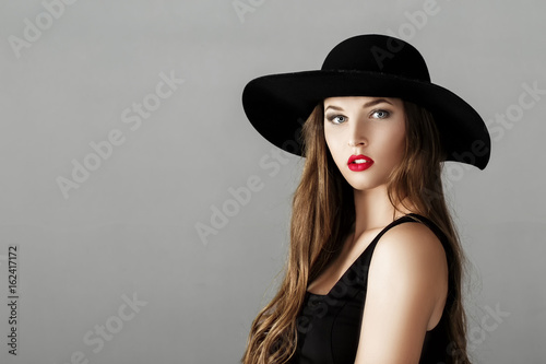 Beautiful sexy woman with red lipstick in black hat