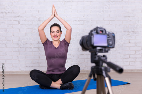 beautiful woman blogger making video about sport and yoga at home