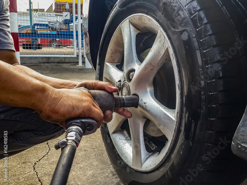 screwing car tire with pneumatic wrench
