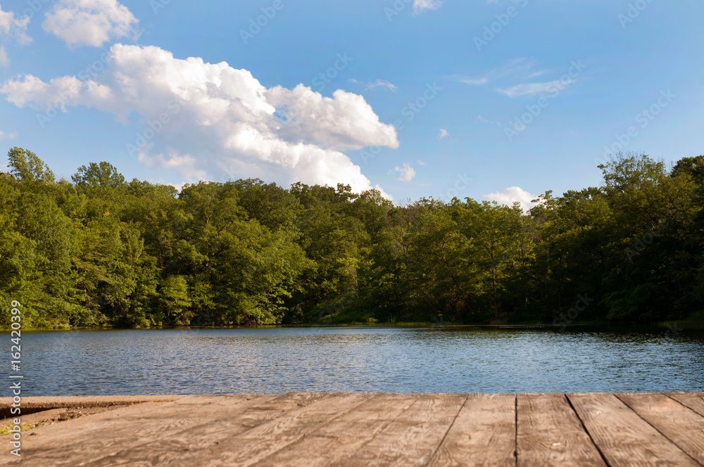 Obraz premium Beautiful forest and lake with a wooden board.