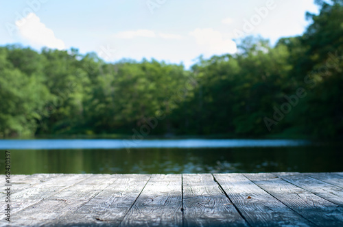 Canvas Print Beautiful forest and lake with a wooden board.