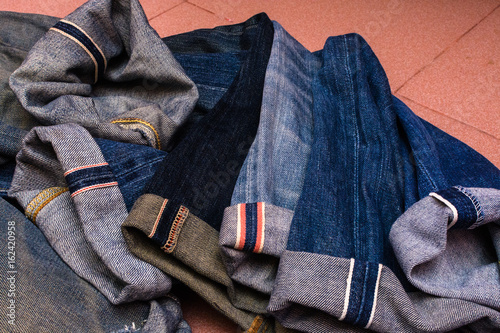 a group of selvedge vintage blue jeans pants or denim isolated