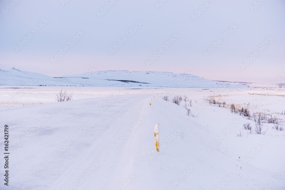 Morning winter drive in the Icelandic mountains by the snowy road