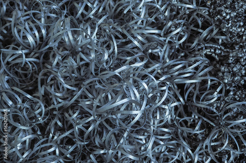Metal shavings in the metal-working factory. Abstract metal background with filter color.
