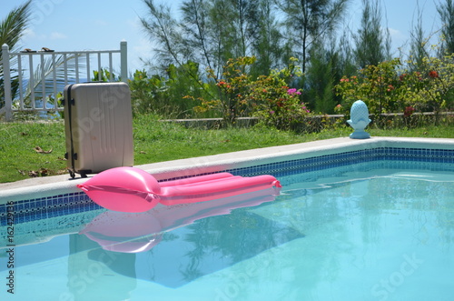 Mattress and suitcase at the pool