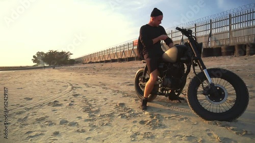 Wallpaper Mural Motorcyclist driving his motorbike on the beach during sunset. Slow motion. Torontodigital.ca