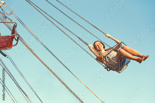 Young girl on a whirligig in amusement park.