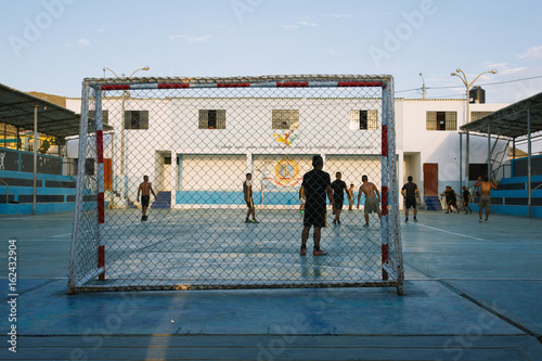 Boys playing soccer on the court