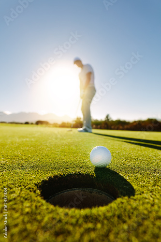 Professional golfer putting golf ball