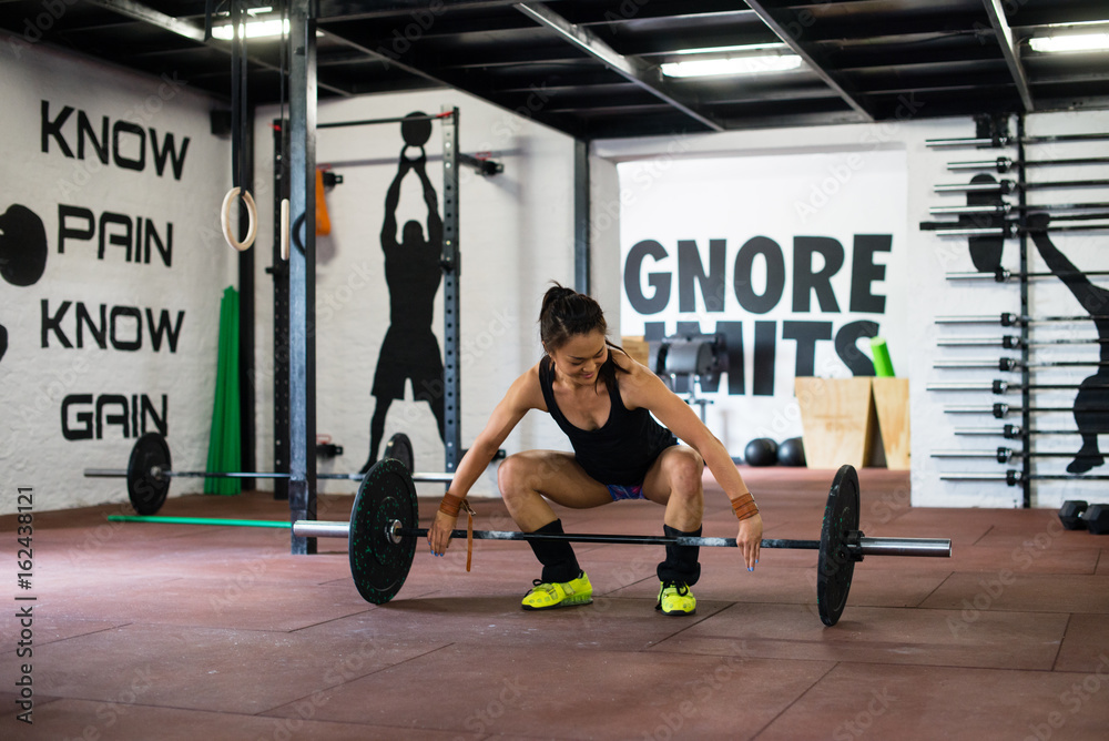 Girl is lifting weights on training Girl is lifting weights on training