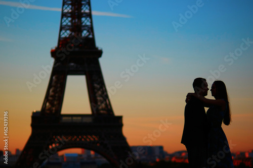 Silhouettes of couple at sunrise or sunset in front of the Eiffel tower © Ekaterina Pokrovsky
