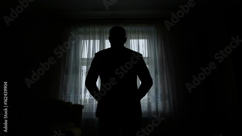 silhouette of a man dressed in the room