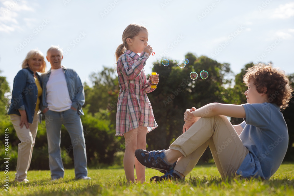 Fotografie Pretty little girl making bubbles