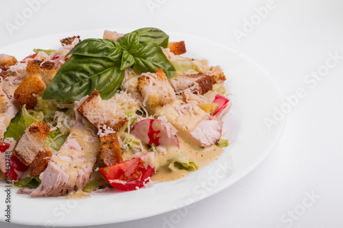 Caesar salad with chicken on a white background