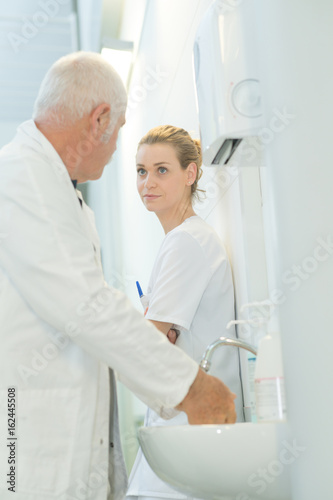 dcotor washing hands and talking to nurse
