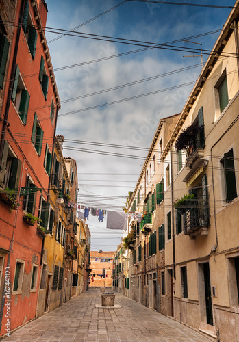 View down colourful back street of Venice with many washing lines.