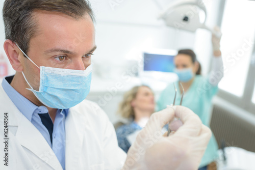 portrait of male dentist preparing his tools