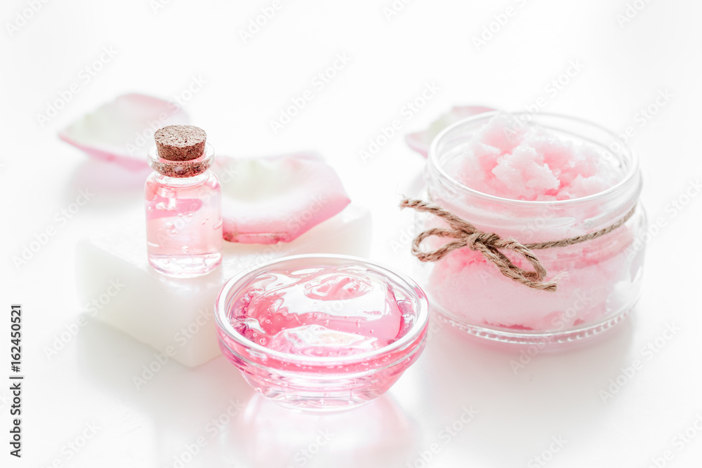 body treatment with rose petals and cosmetic set white desk background body treatment with rose petals and cosmetic set white desk background
