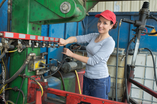 young sexy brunette woman working as industrial mechanic photo