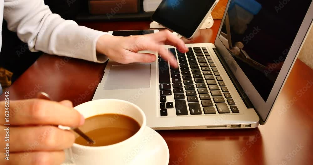 4k female sitting on the table and stir the coffee,browing webpage on the laptop,keyboard input,hands typing on a computer keyboard,write article,writing report. 4k female sitting on the table and stir the coffee,browing webpage on the laptop,keyboard input,hands typing on a computer keyboard,write article,writing report.