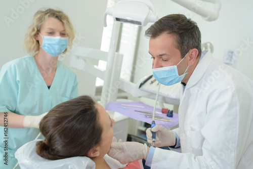 patient and dentists smiling in dentist office