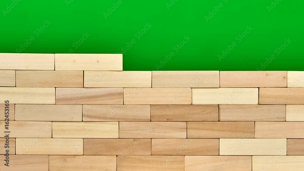 Wooden bricks are gathered into wall. Stop motion, green screen