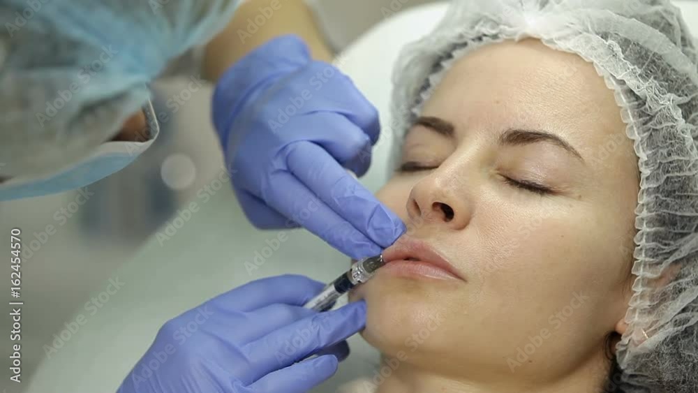 Lip augmentation in beauty salon. Beautician makes injection plastic lips. Lip augmentation in beauty salon. Beautician makes injection plastic lips.