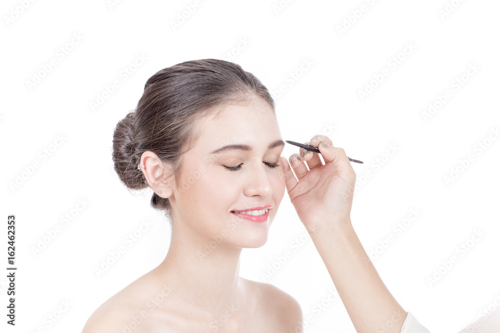 Makeup artist applies brushed at woman face. Beautiful woman face. Perfect makeup, isolated on white background, 20s year old. Makeup artist applies brushed at woman face. Beautiful woman face. Perfect makeup, isolated on white background, 20s year old.