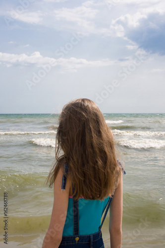 Young girl with long blond hair on the sea coast