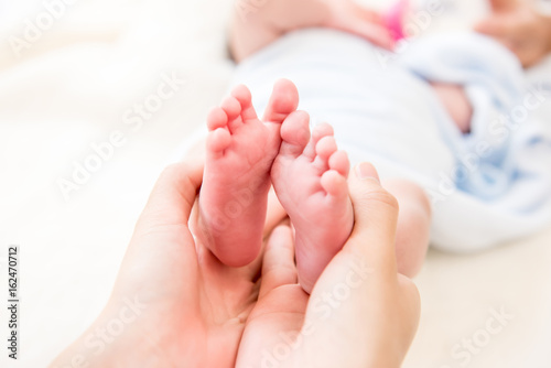 Mother hands gently holding small baby feet © Atstock Productions