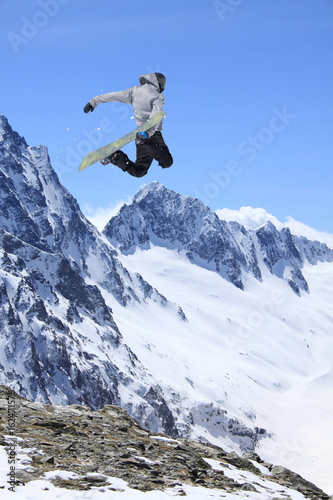 Snowboarder jumping in the mountains. Extreme sport.