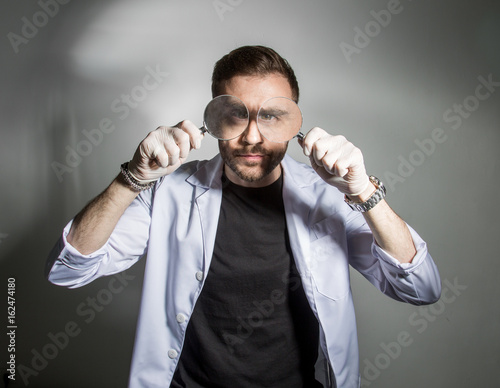 Foto Huge eyes of a scientist using a magnifying glass