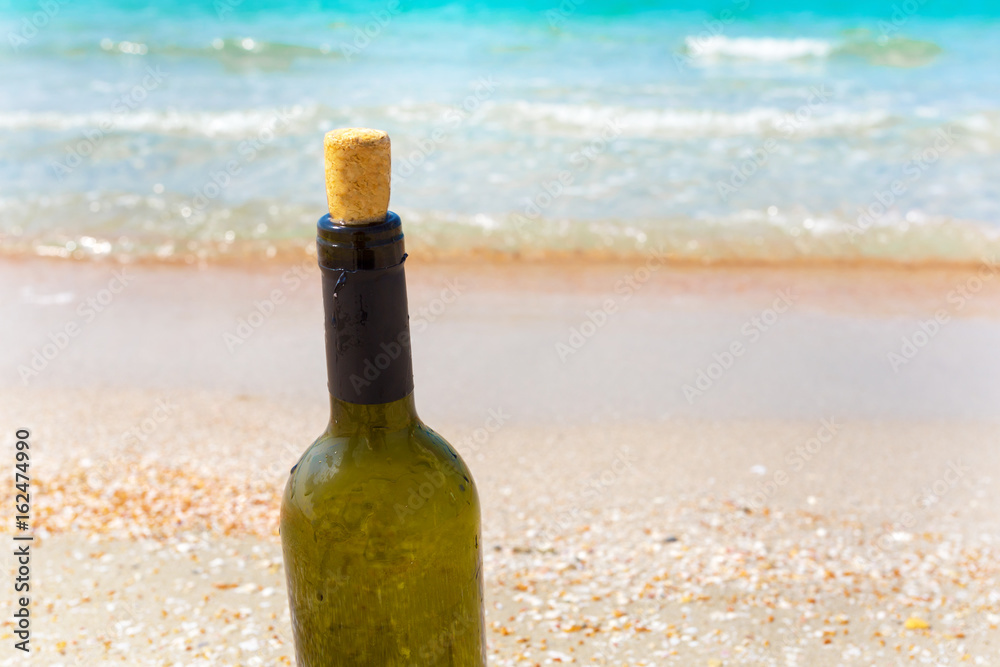 Bottle of wine in sand on the beach Bottle of wine in sand on the beach