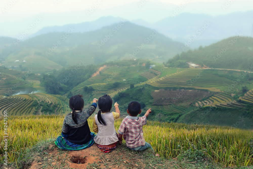 Three children looking forward on the top of terraced of rice field at Vietnam.Together concept.