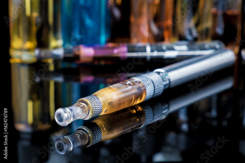 Photos Electronic cigarette with e-liquid bottles in background