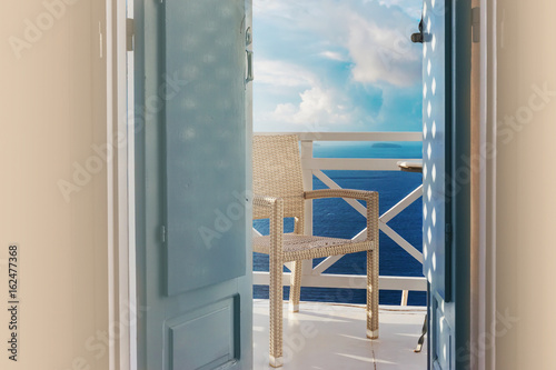 Sea view trough traditional wooden shutters on Santorini island  Oia  Greece. Balcony overlooking from a hotel romantic room.