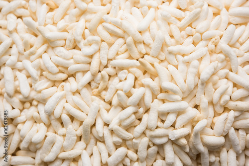 Puffed rice also known as Murmura or Murmure in hindi served in a colourful ceramic bowl or plate or over gunny bag, isolated, selective focus photo