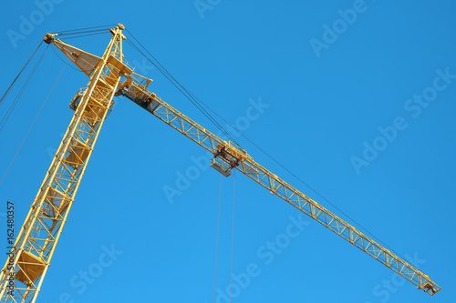 A yellow crane and a blue cloudless sky.