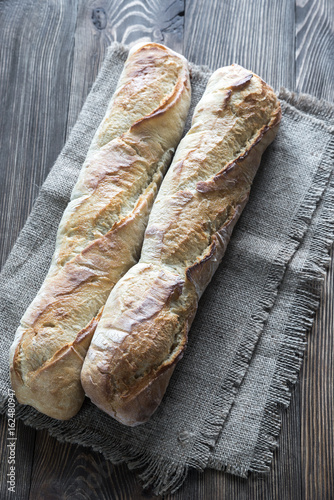 Two baguettes on the wooden background