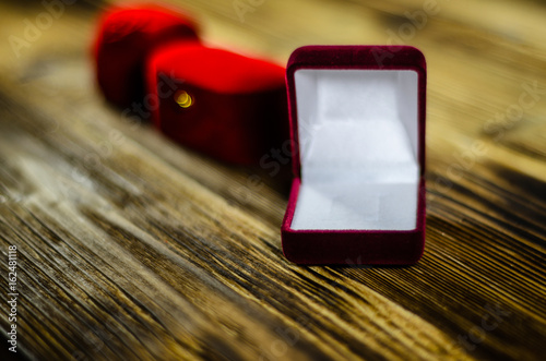 Different red jewelry boxes on wooden table