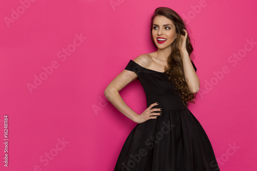 Cheerful Elegant Woman In Black Dress Is Looking Away © studioloco